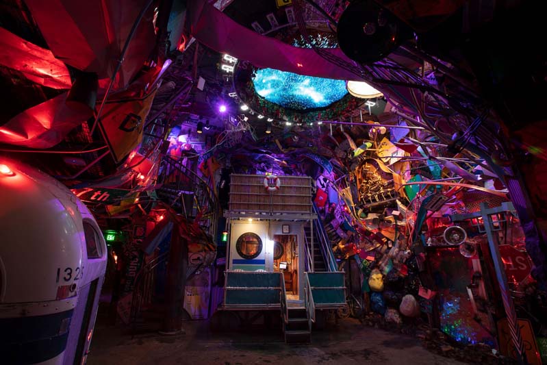small house within a large cave of found objects including instruments that can be played inside Meow Wolf Denver