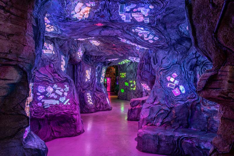 Cave with crystals embedded in the walls leading to an unknown space in Meow Wolf Denver’s Convergence Station