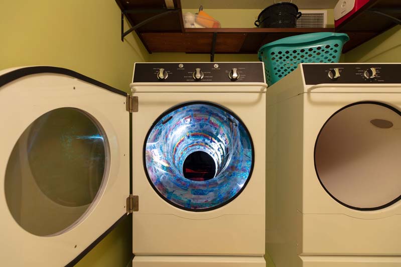 dryer with a swirling portal inside at Meow Wolf