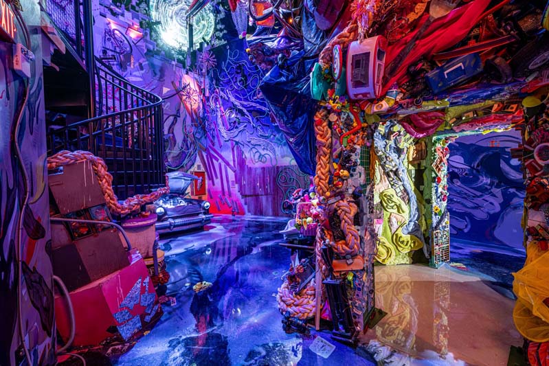 room with lots of swirling lines and a car in the distance with a doorway leading into a space with bright light
