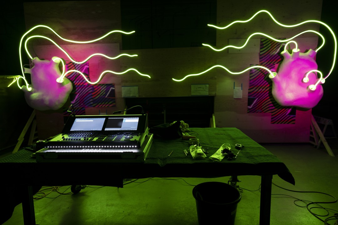 Computer with neon hearts and lights streaming out