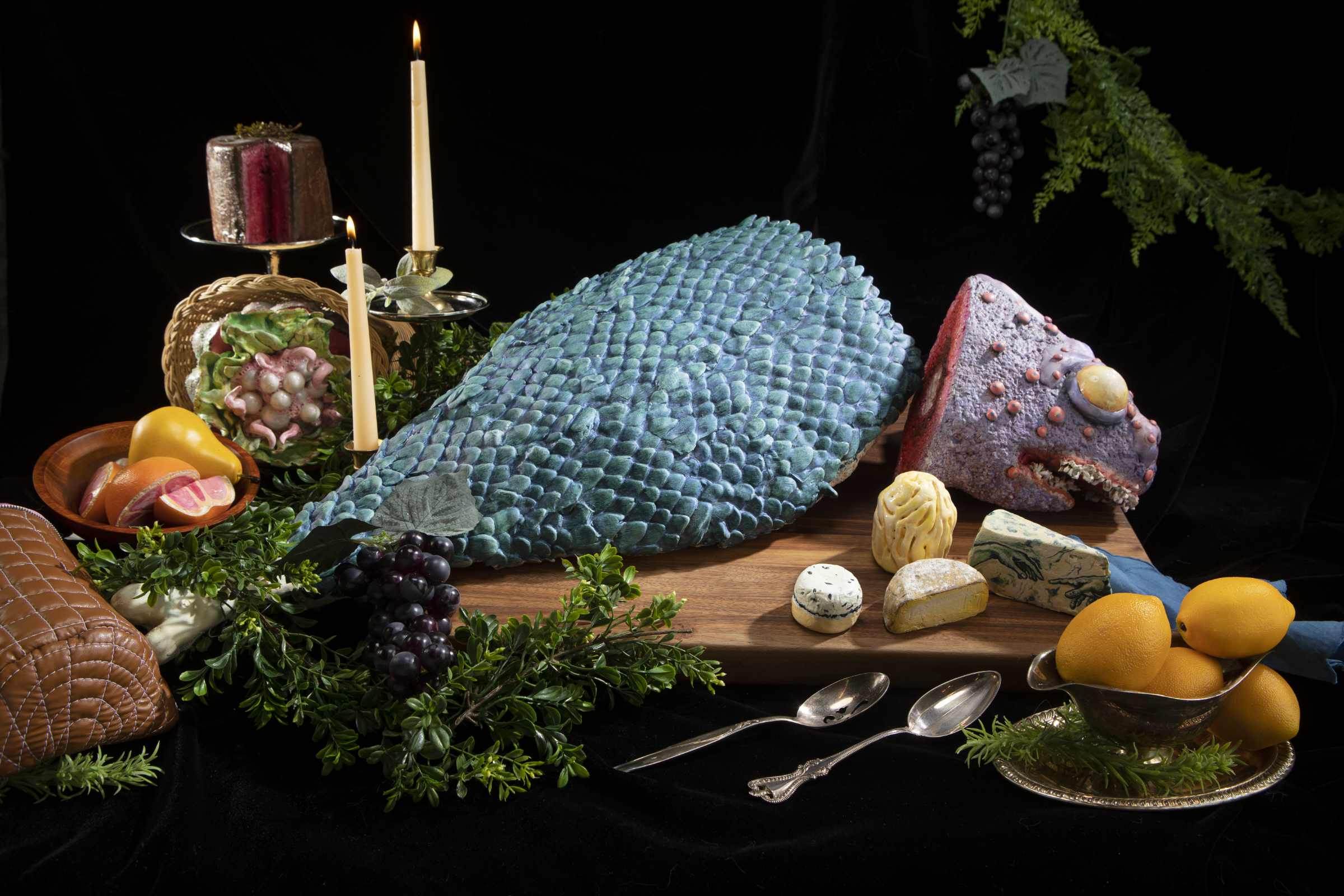 Artistic fish on a platter with cheeses around it