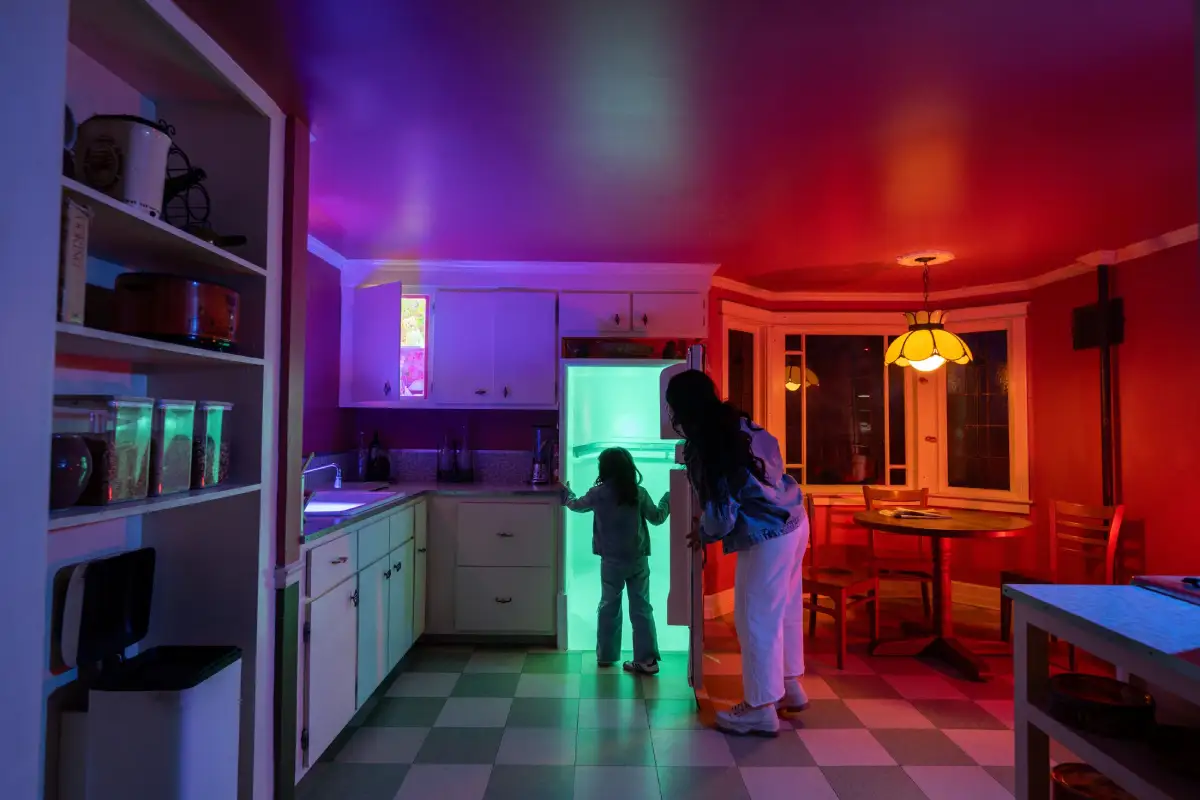 The silhouette of a child walking through a refrigerator doorway with a parent watching at Meow Wolf Santa Fe.