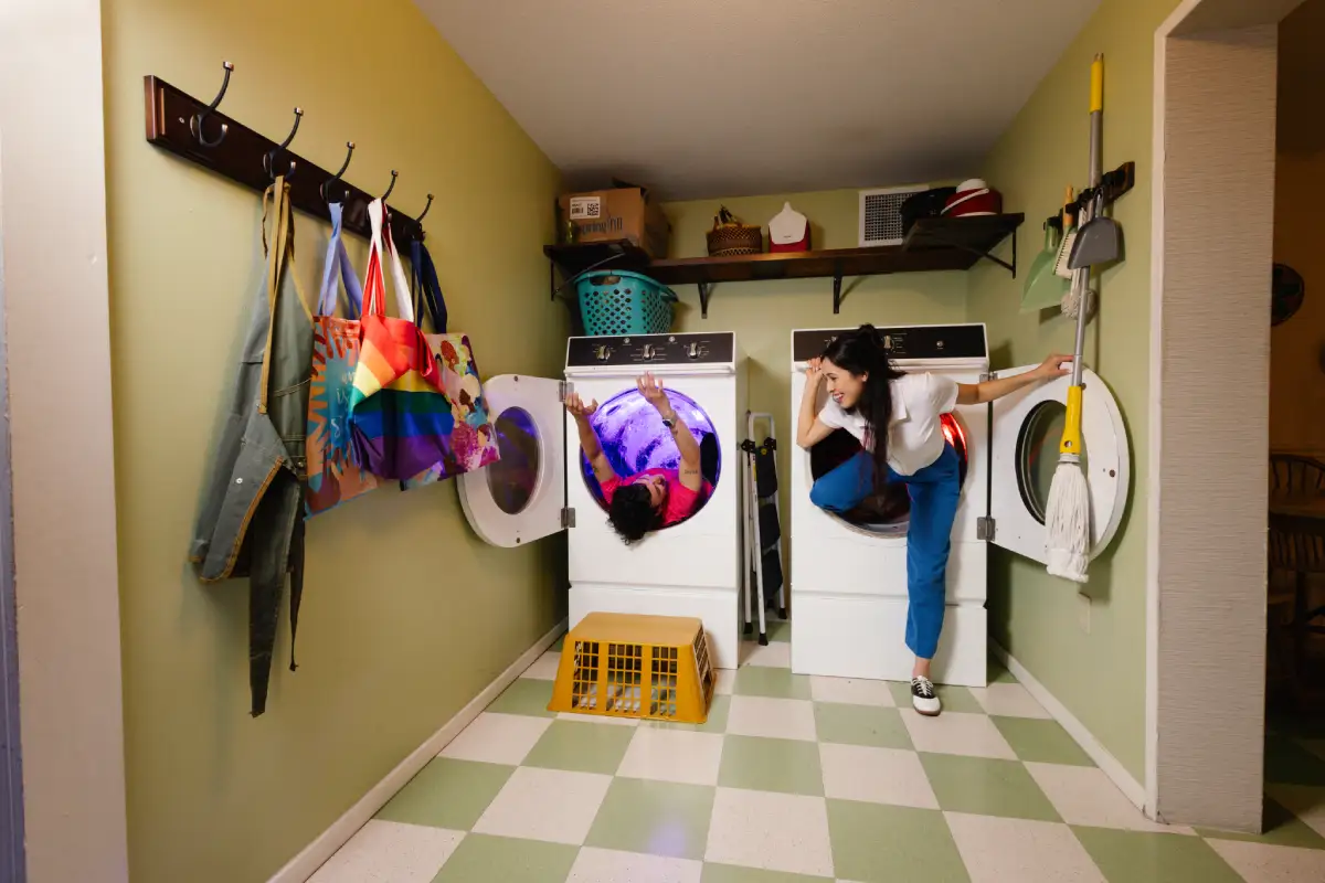 Two guests going into washing machine slides at Meow Wolf Houston