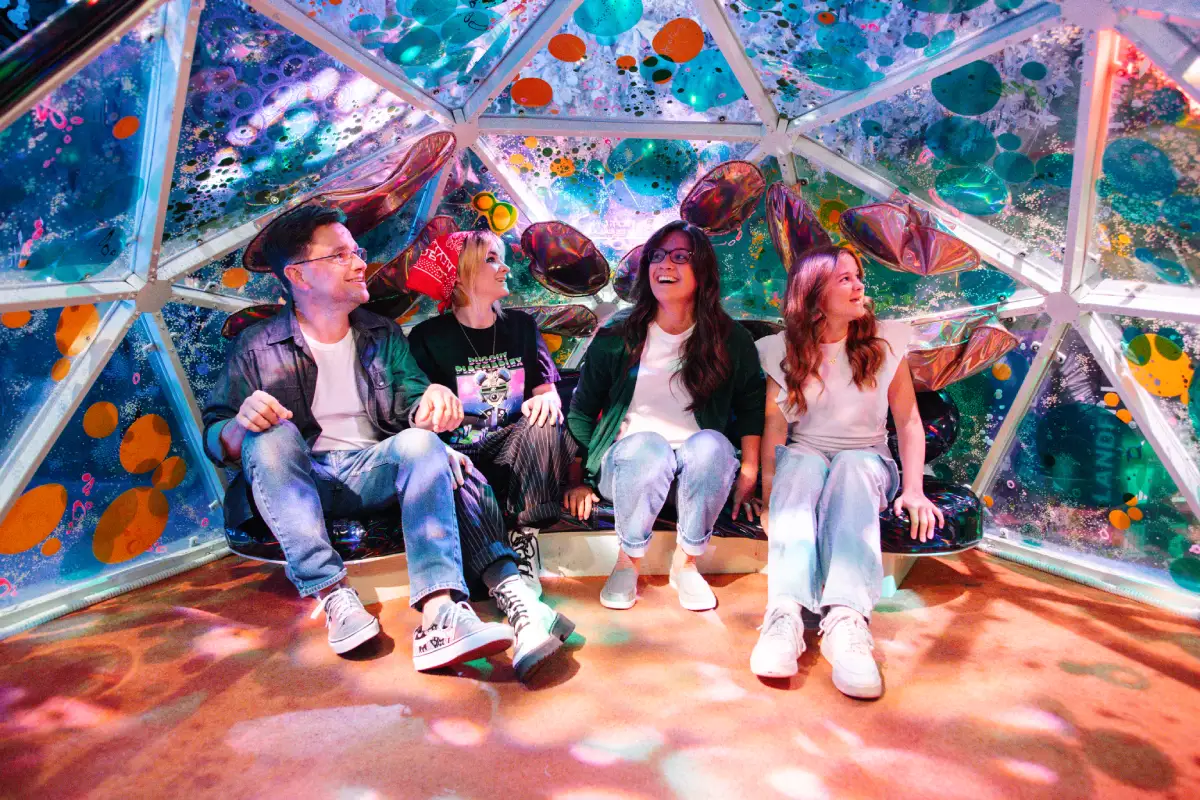A family inside a colorful geodesic dome at Meow Wolf Houston