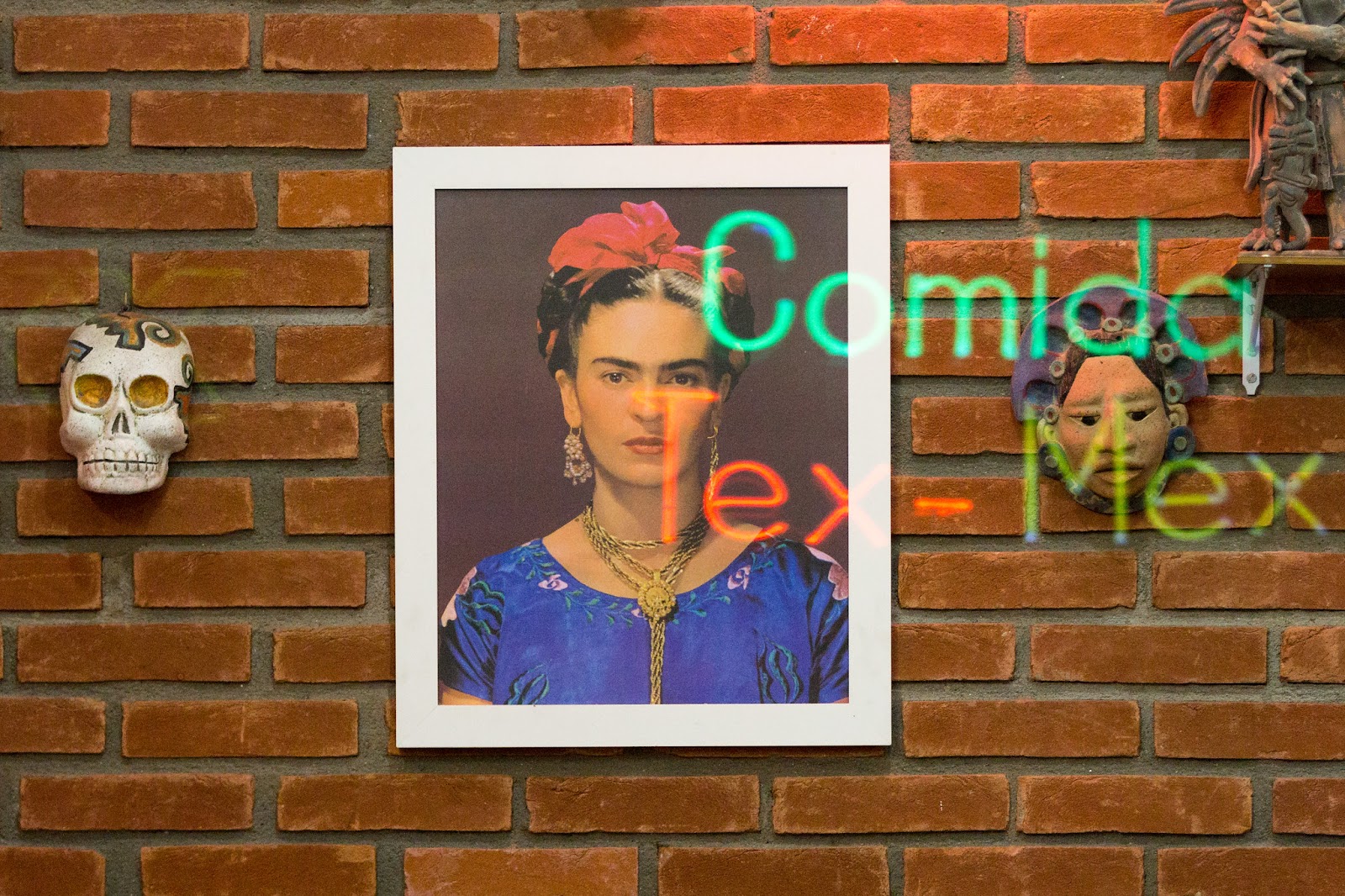 Frida Kahlo artwork with Tex-Mex neon sign in the reflection