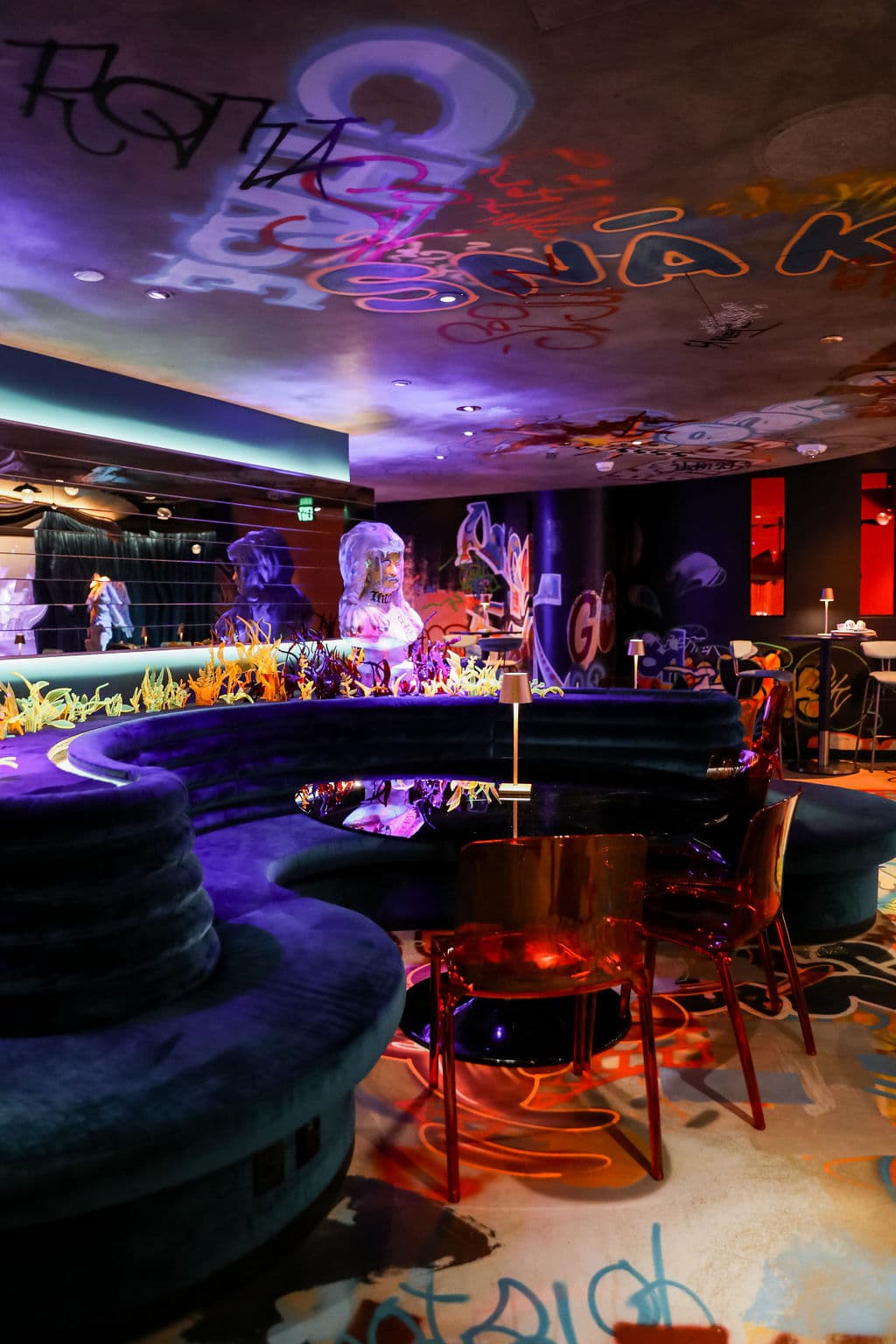 lounge bar space with art deco furniture and grafitti all over inside Meow Wolf Denver