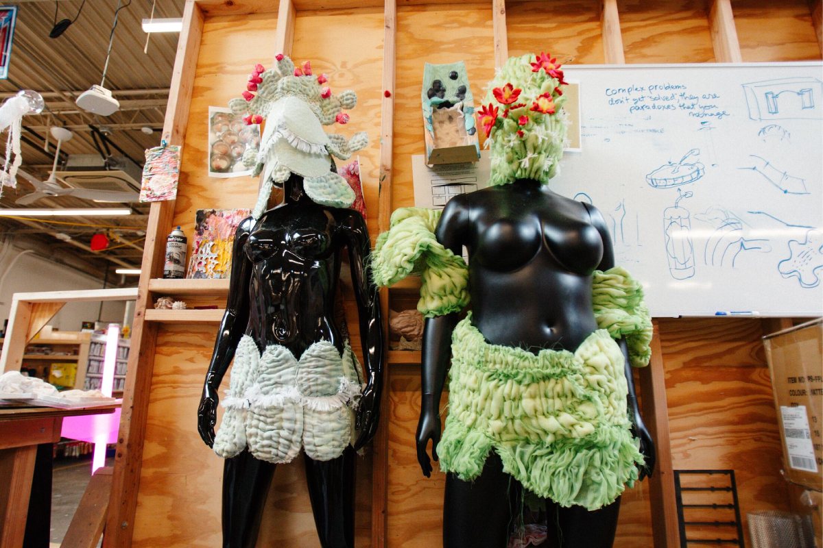 Two mannequins displaying quilted head and body garments in white and green.