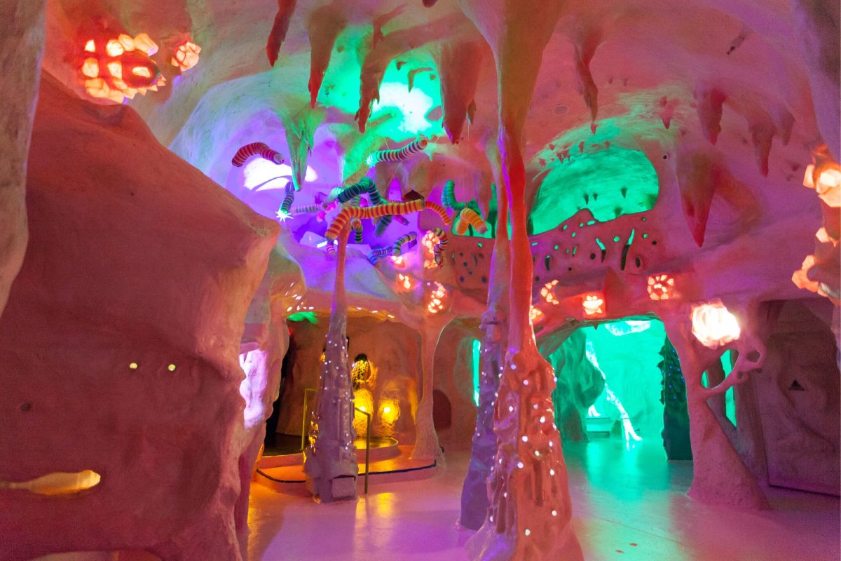 A white clay cave with green, purple and yellow lighting.