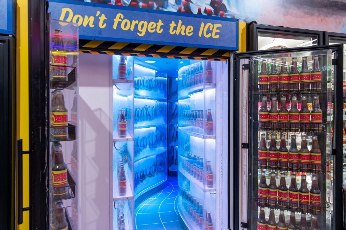 An open cooler door that has a pathway leading into it. 