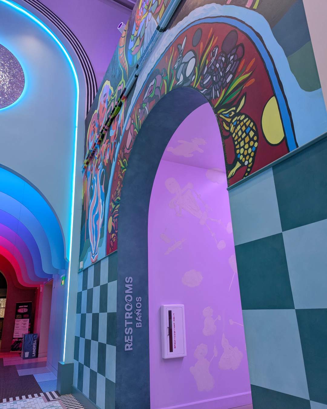 A colorful archway with a checkered wall underneath and a walka
