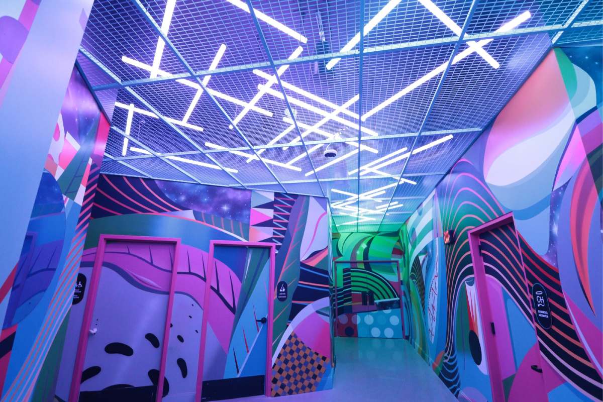 A bright colored patterned room with neon lights above.