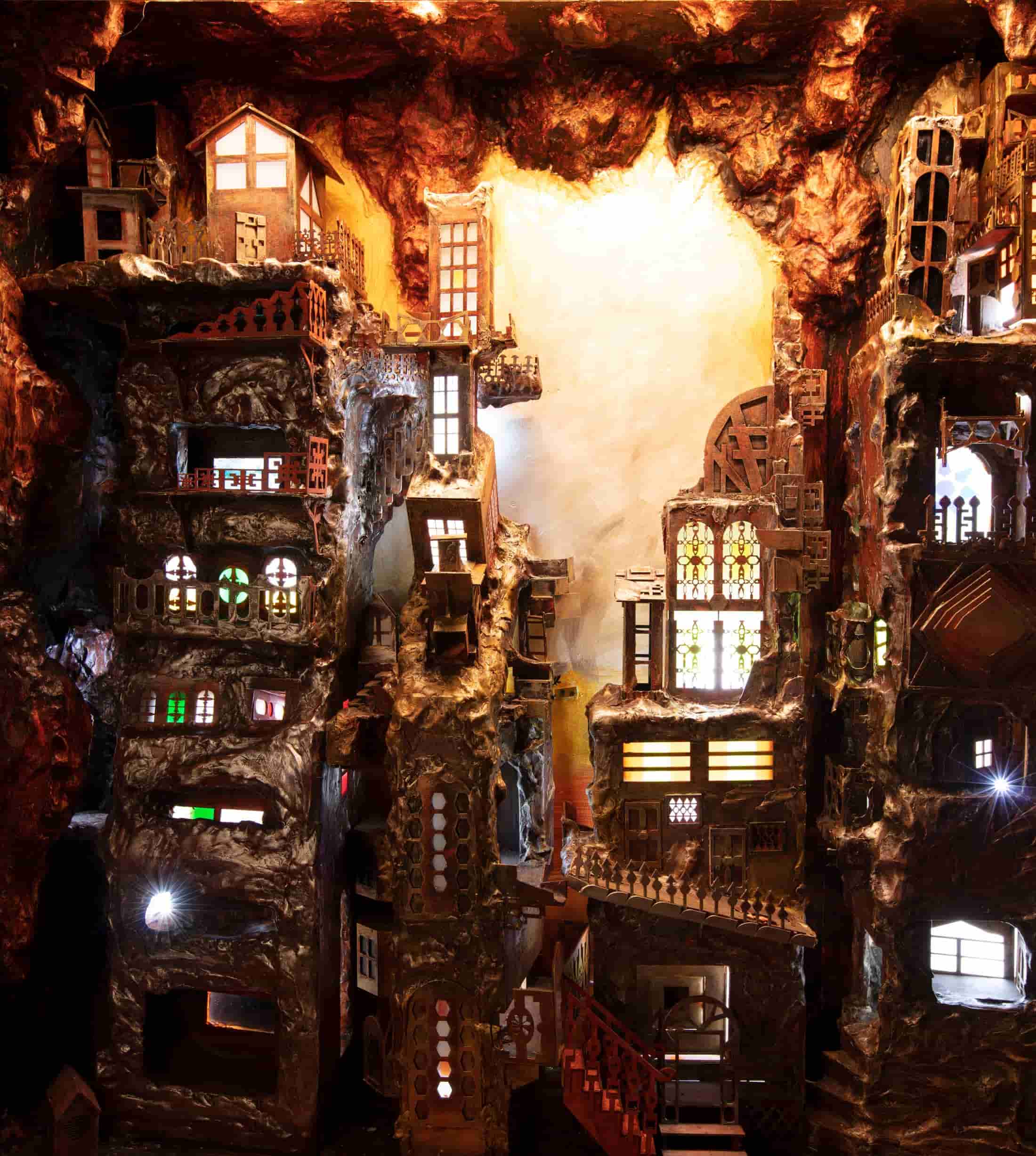 A set of windows and buildings lit up in a cave, the Seven Monolith Village.