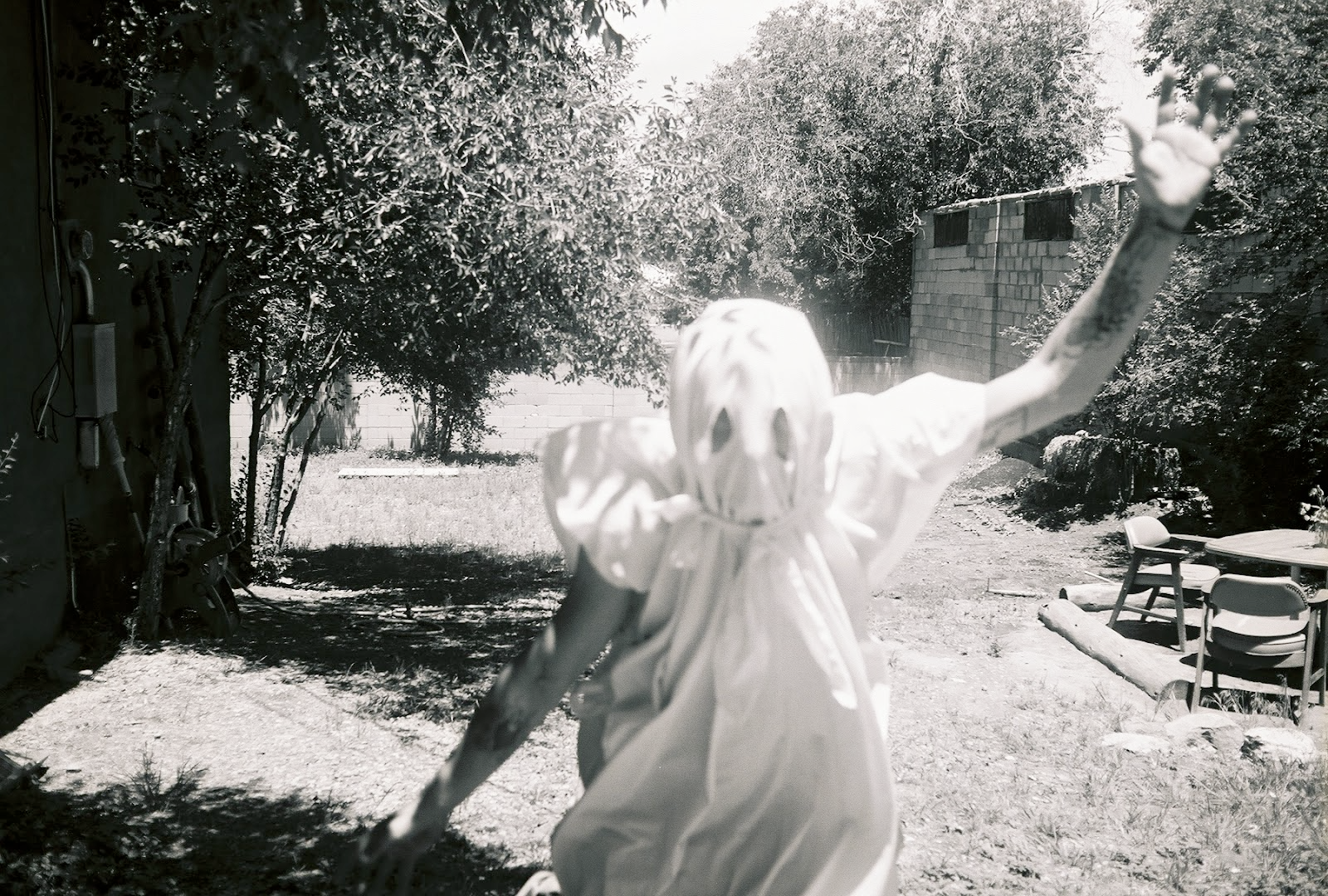 person in a white sheet dressed as a ghost with eye holes cut in