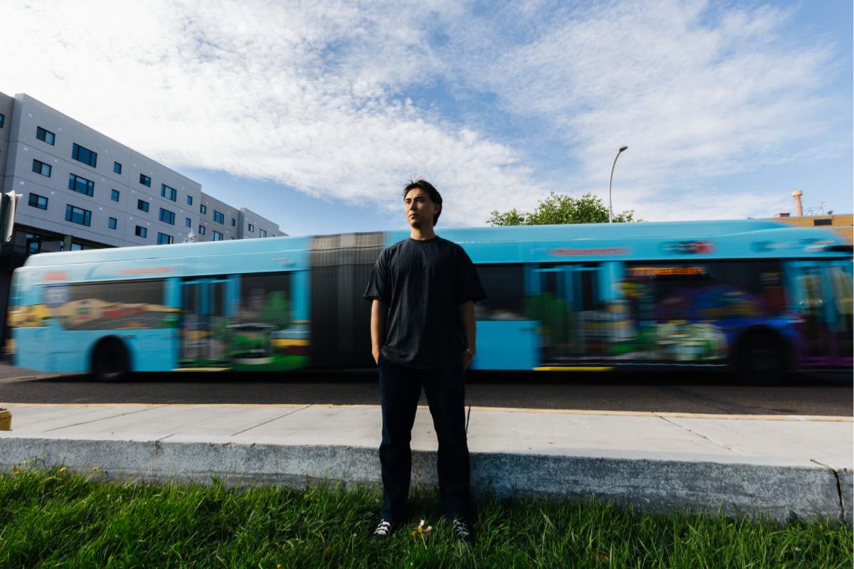 Man standing in front of a blurry decorated bus.