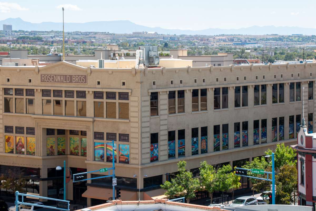 A building with a mural wrapping around the second floor windows.