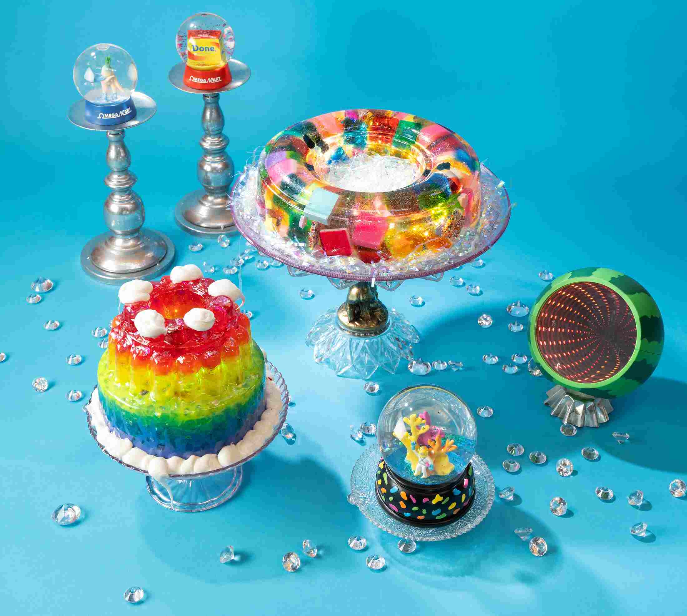 Three snowglobes, a rainbow terrine, and a rainbow gelatin sit against a blue background.