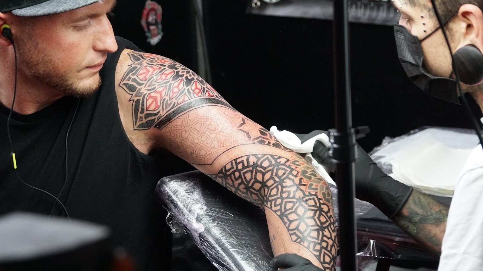 A tattoo artist working on an intricate sleeve