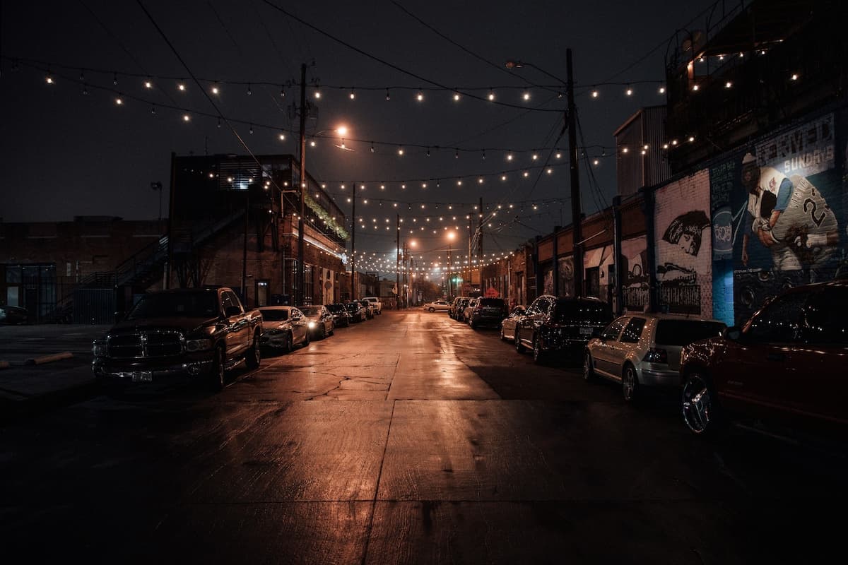 city street at night with cars parked on either side