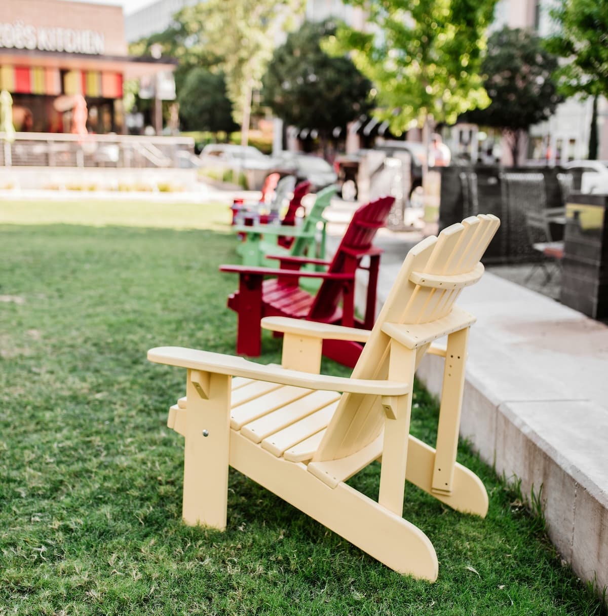 wooden chairs on a green grassy lawn behind a building in Dallas
