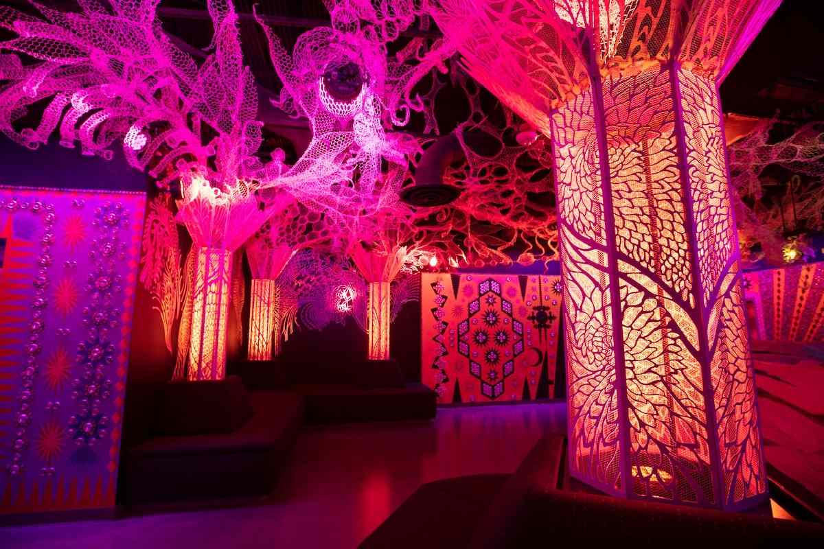 Glowing pink and orange trees against a dark ceiling.