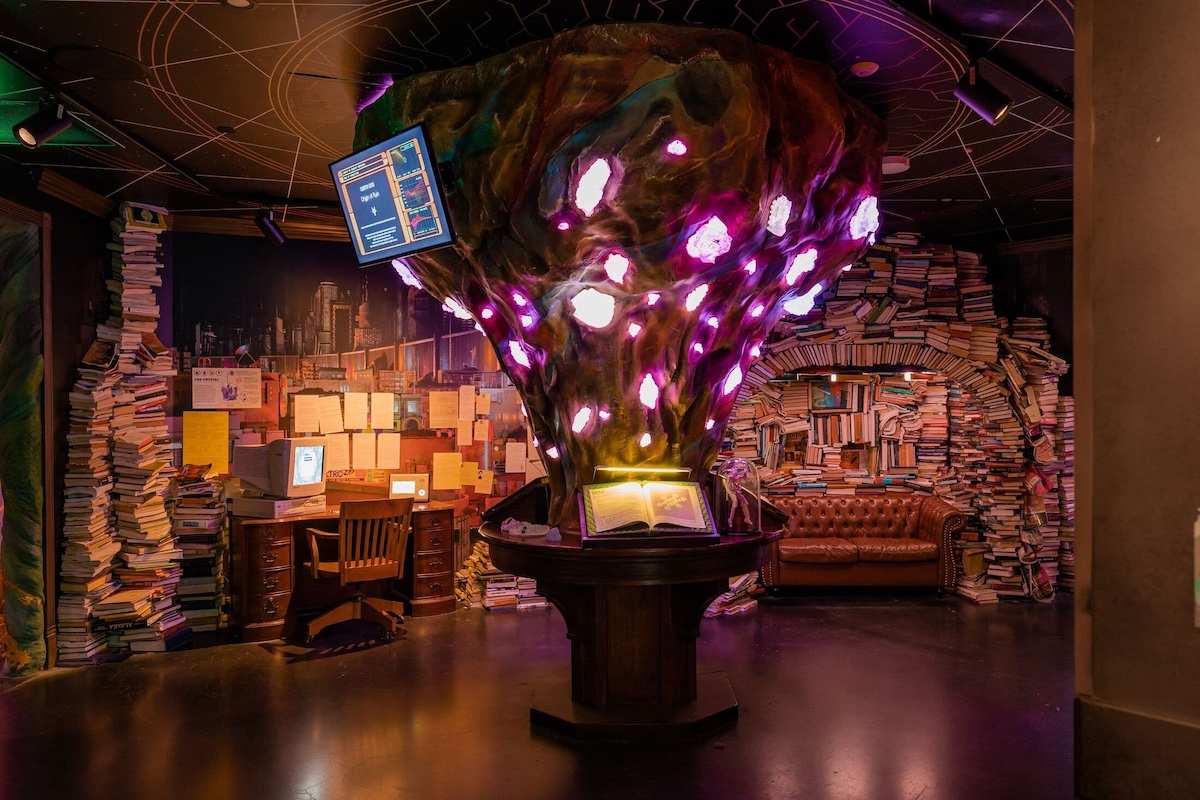 A glowing tree in the center of a room with lots of papers, books, and a couch.