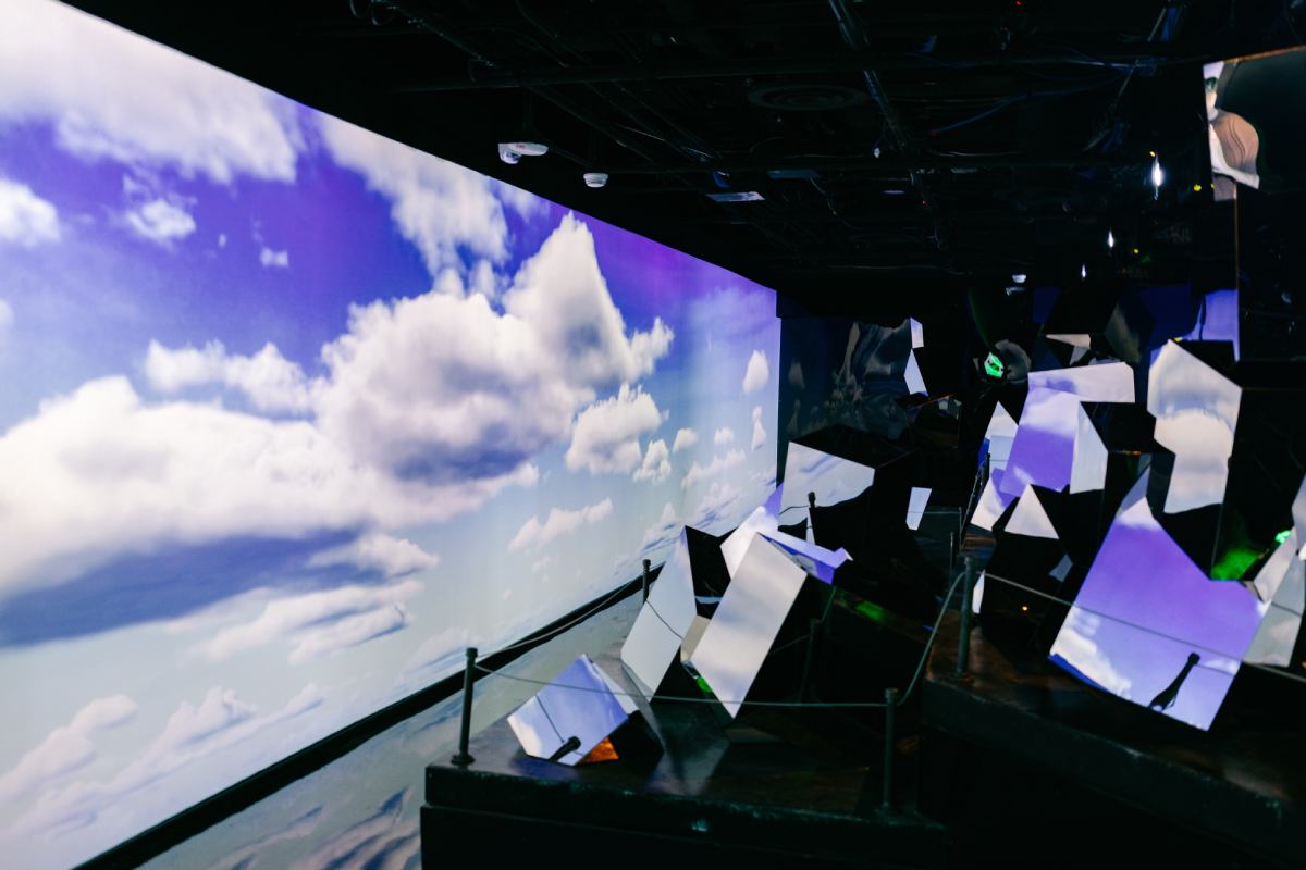 Clouds on a screen on the left and on the right, lots of mirrors inside Meow Wolf.