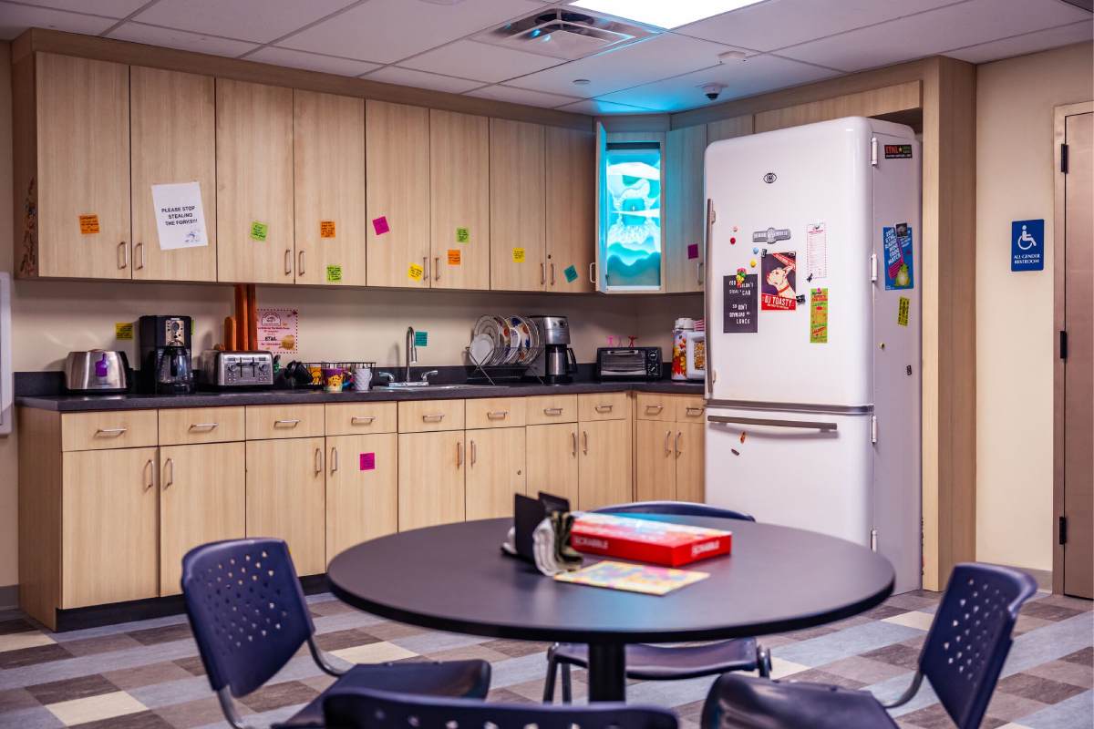 A seemingly normal break room with a table and fridge inside Meow Wolf Houston.