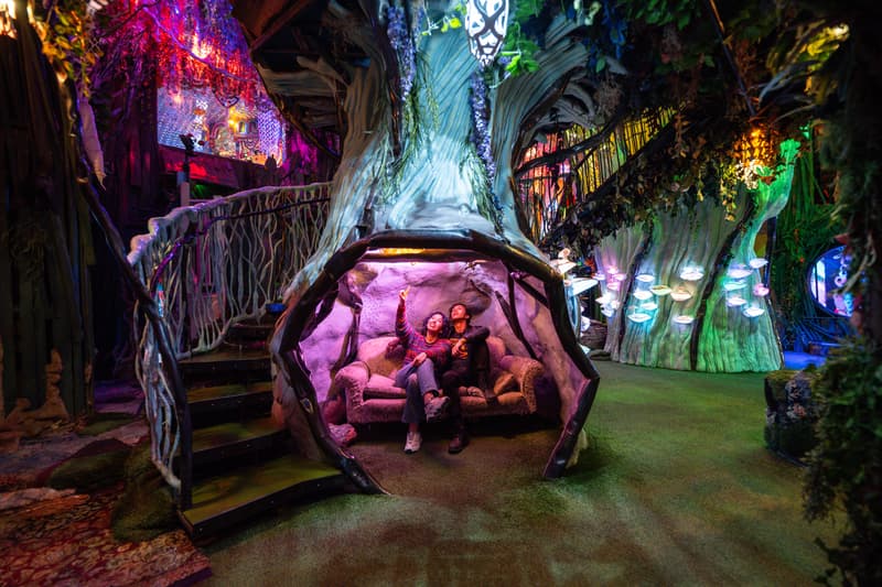 Two people sit under a domed art installation called Treenado at Meow Wolf Santa Fe’s House of Eternal Return