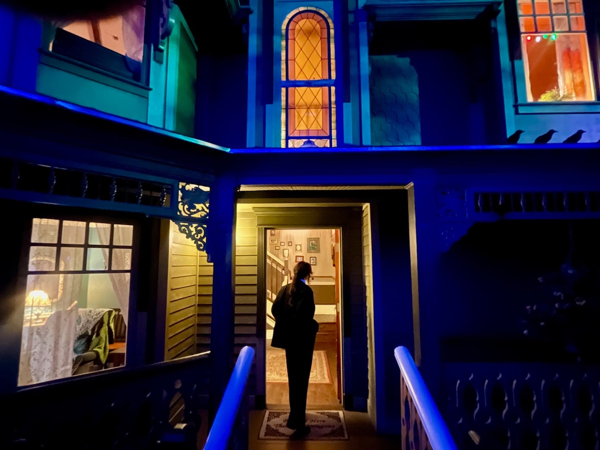 PHOTO OF SUIT-WEARING INVESTIGATOR STANDING IN FRONT OF HOUSE OF ETERNAL RETURN