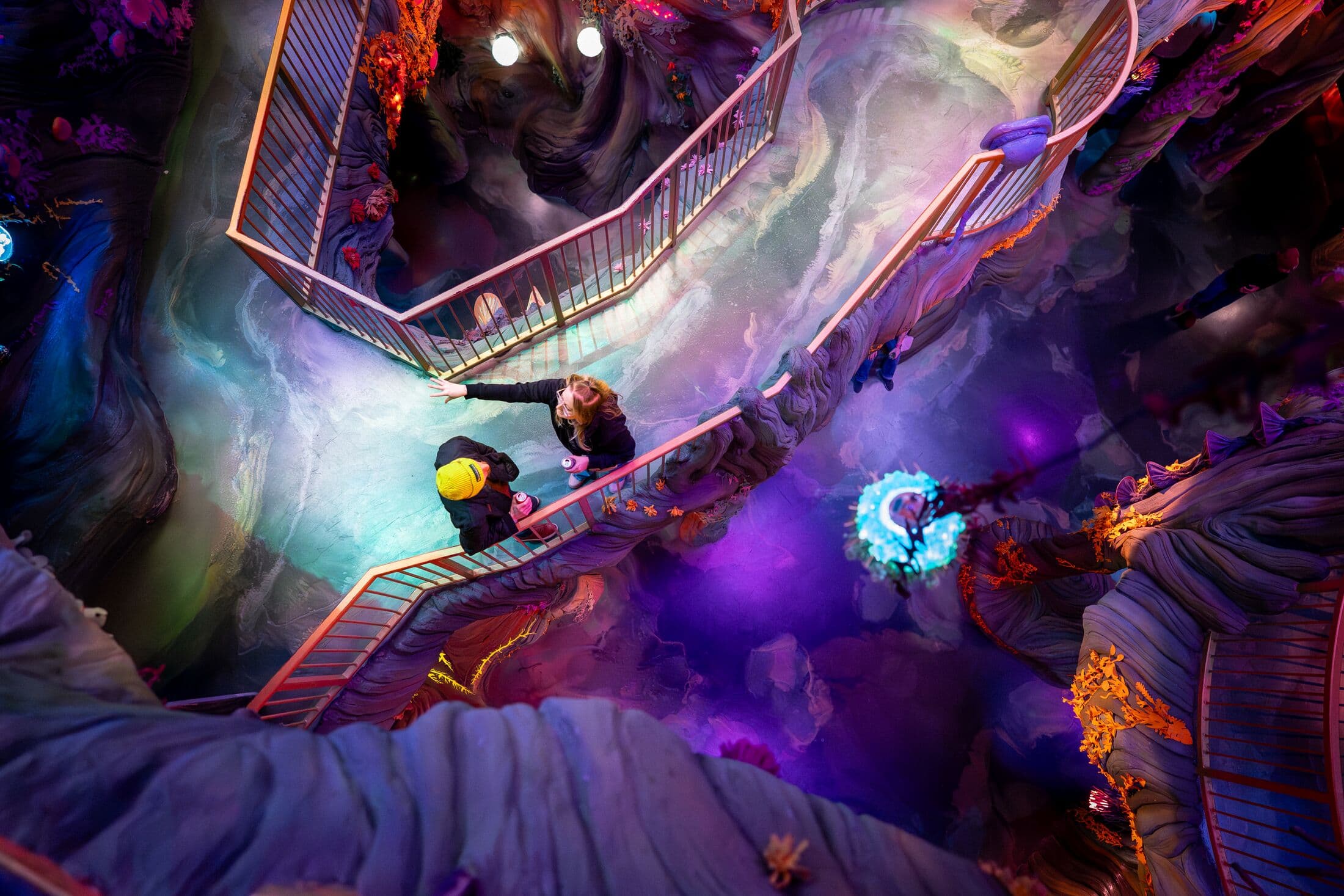 two people standing on a walkway within a sixth dimensional swamp space