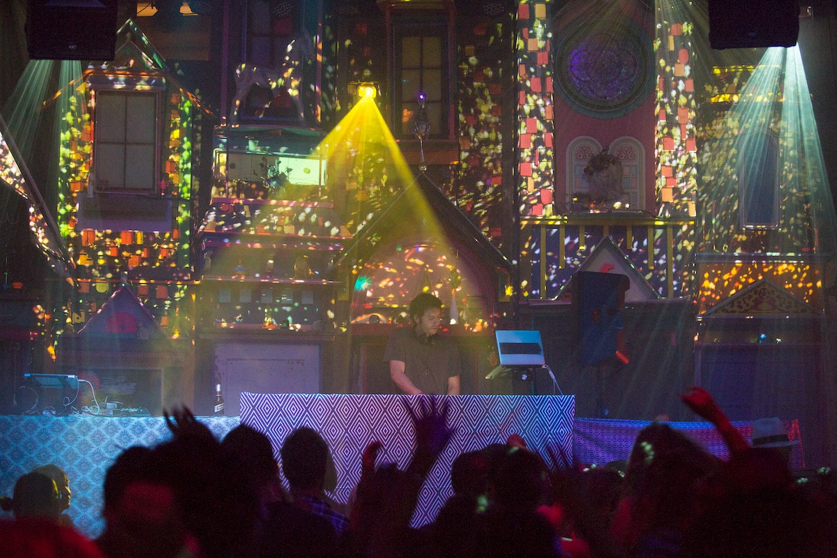 Fancy Town view from behind a crowd dancing to a DJ in Meow Wolf Santa Fe