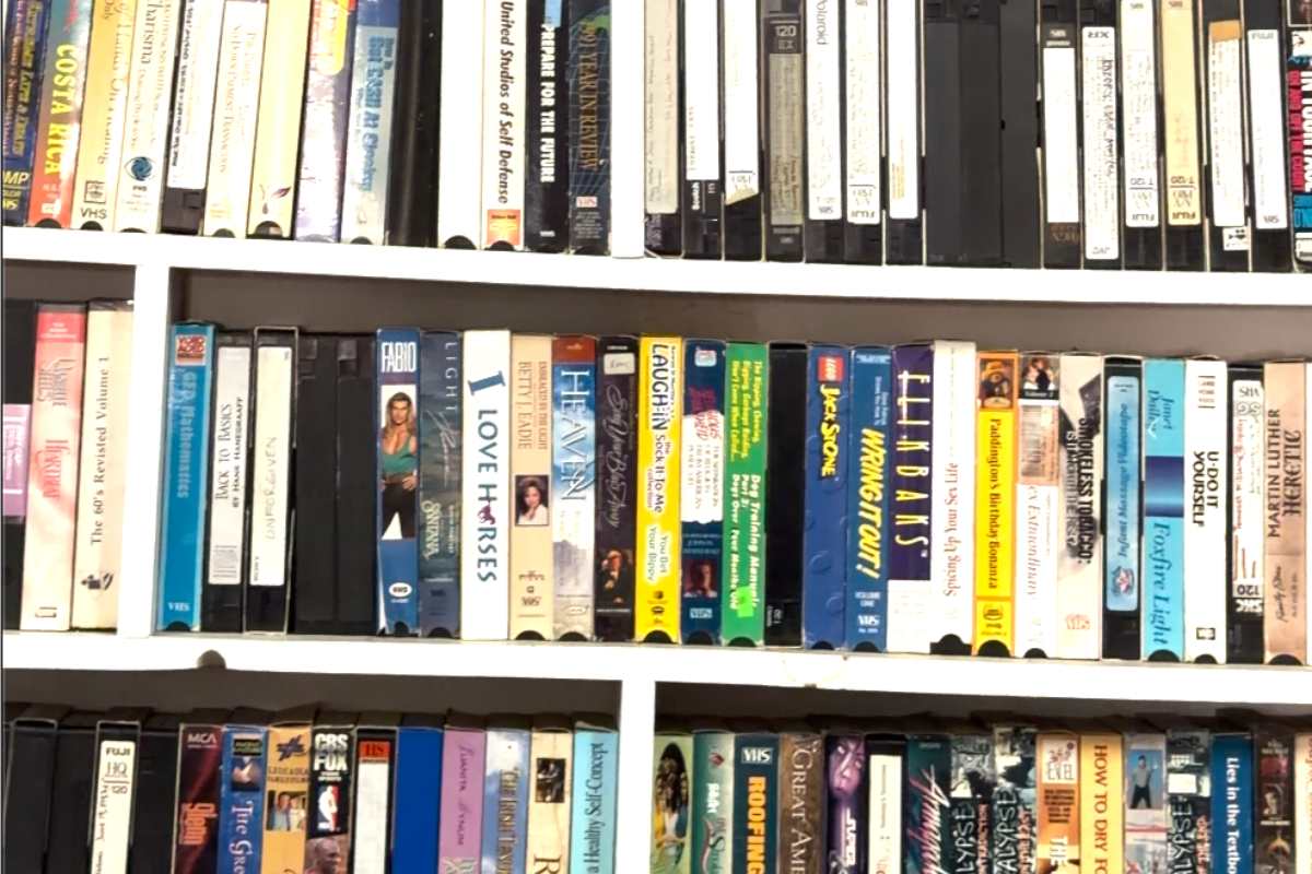 Full bookshelves of VHS tapes of various titles.