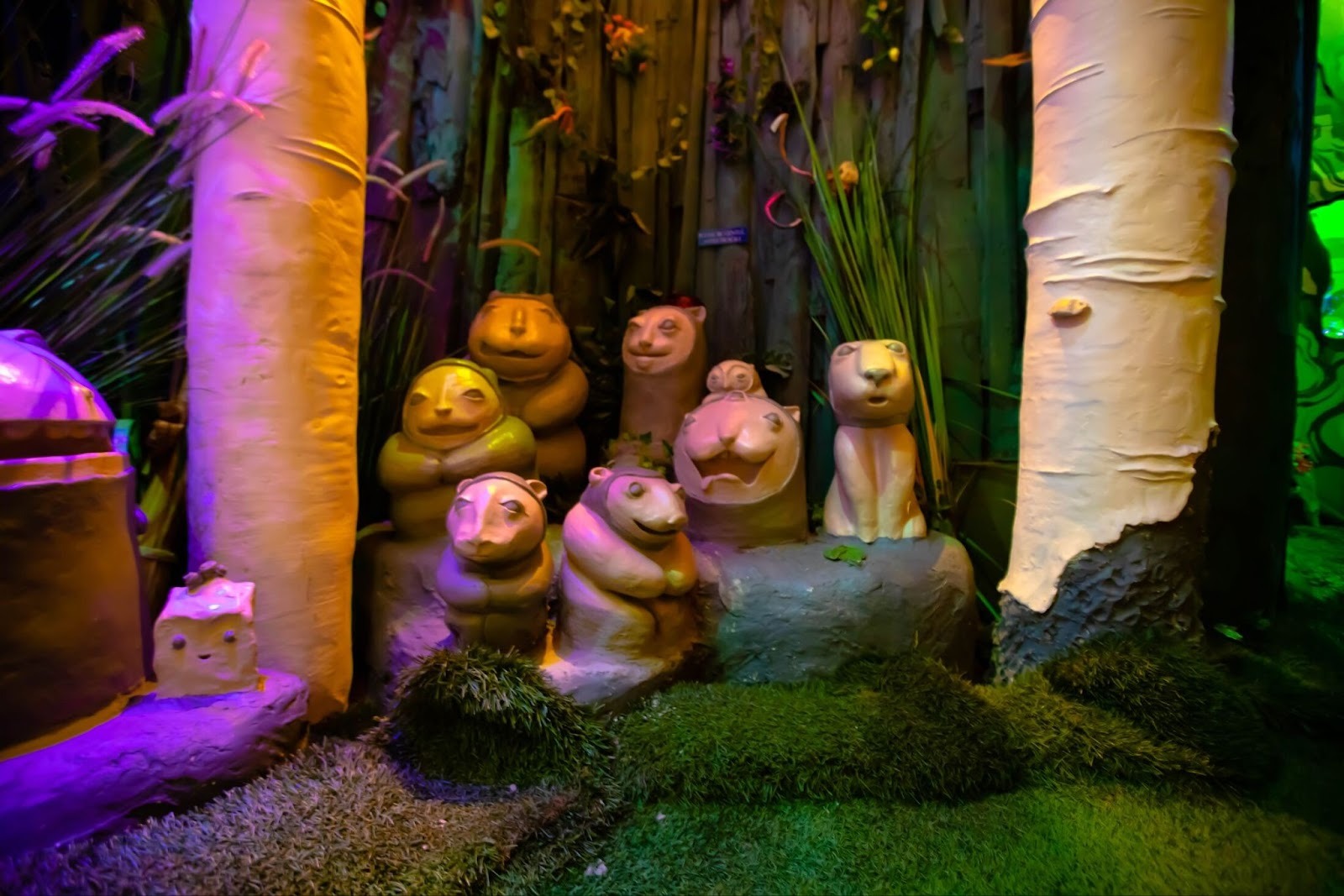 Forest creatures in a group huddled between some trees.