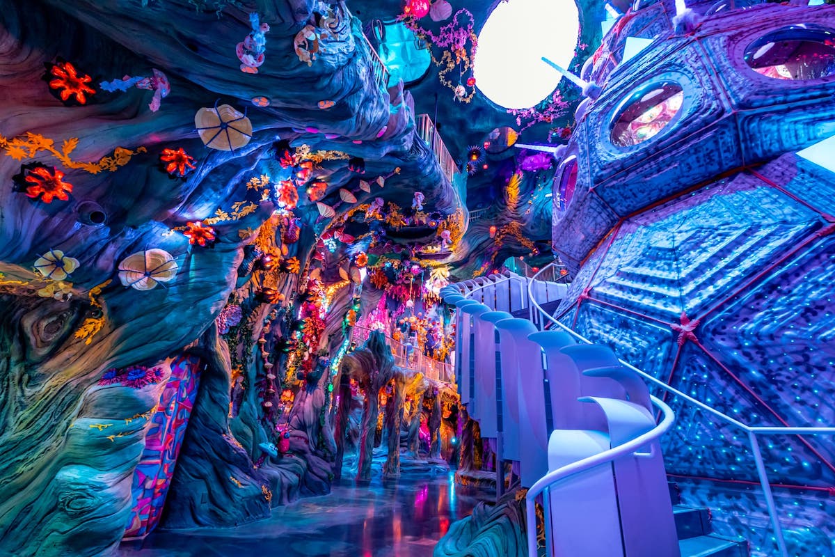 looking up at a large beehive shaped structure in a purple hued room