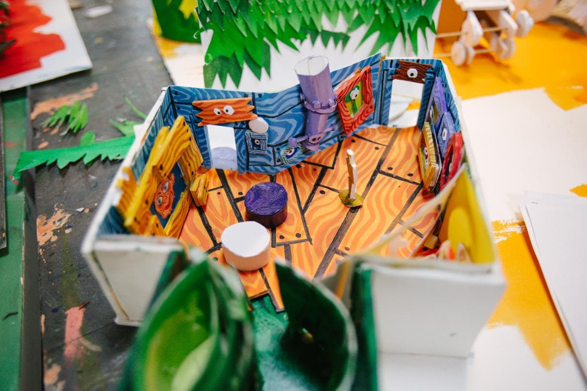 View of a table with a small model house and several other projects