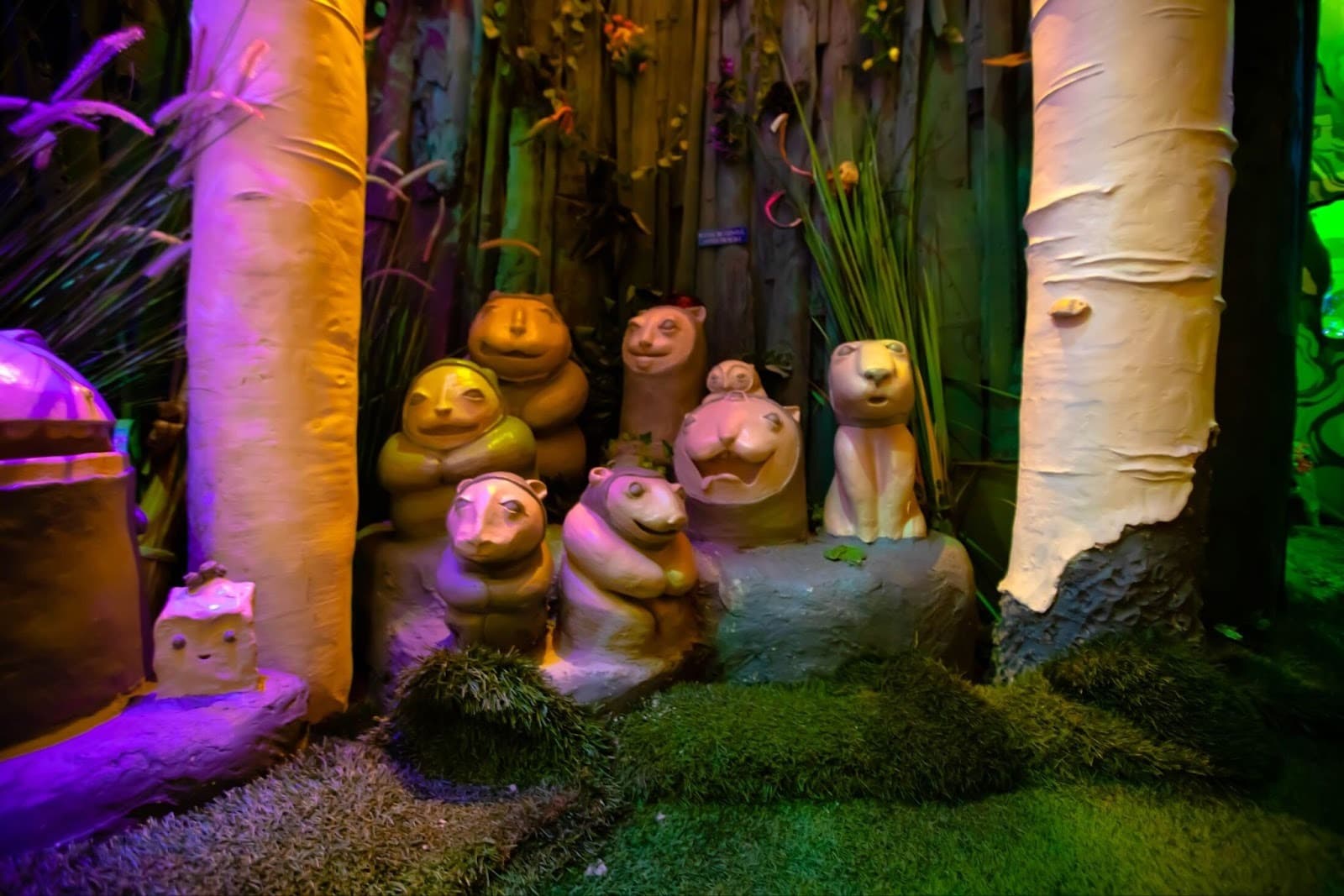 Forest creatures in a group huddled between some trees.