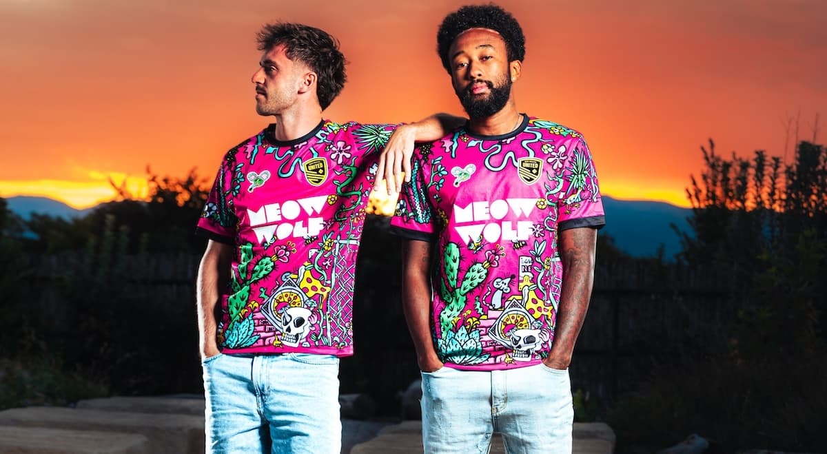 two people wearing bloom pink NM United jerseys against a sunset